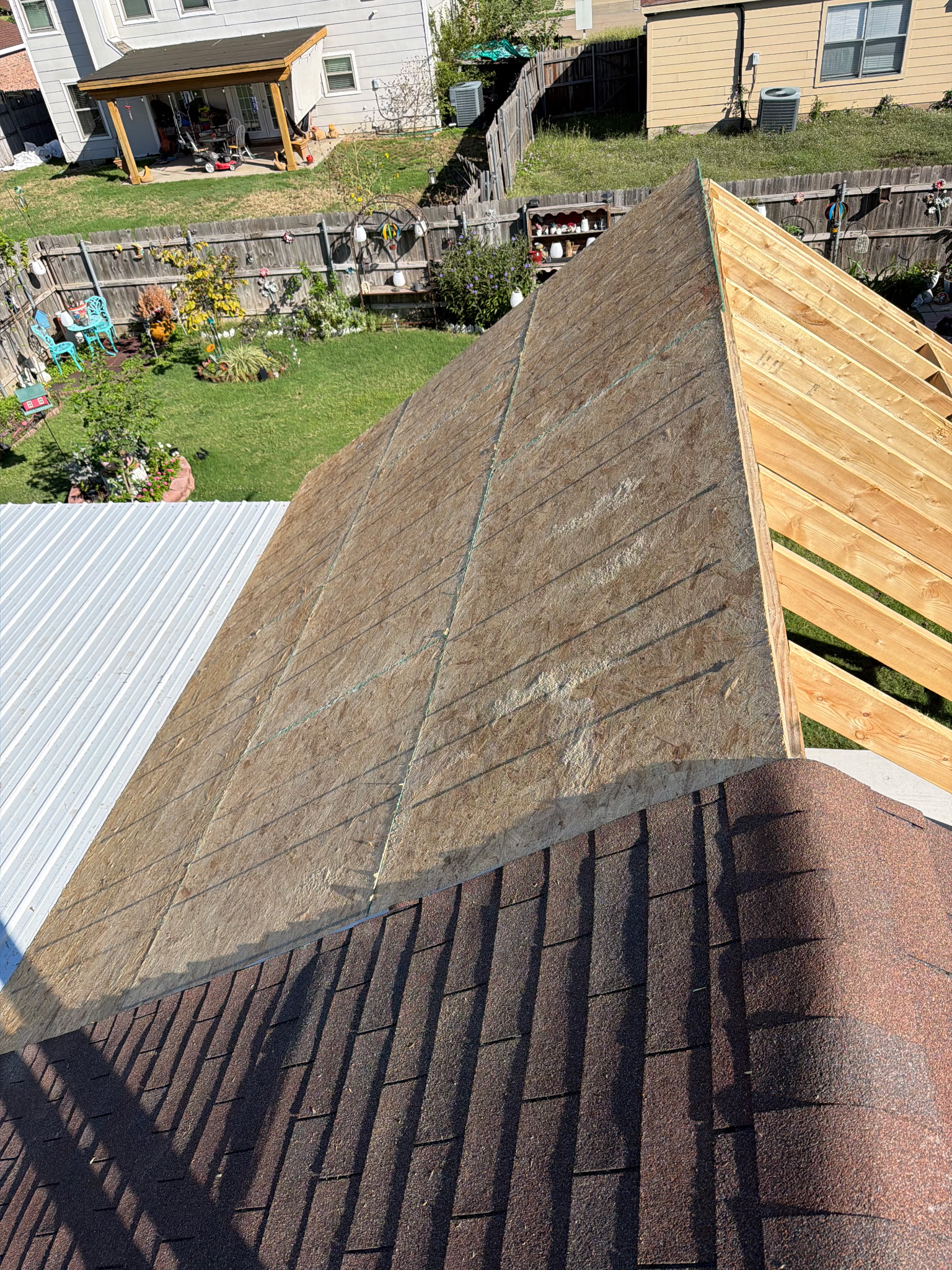 Roof decking and adjoining shingle roof viewed from above