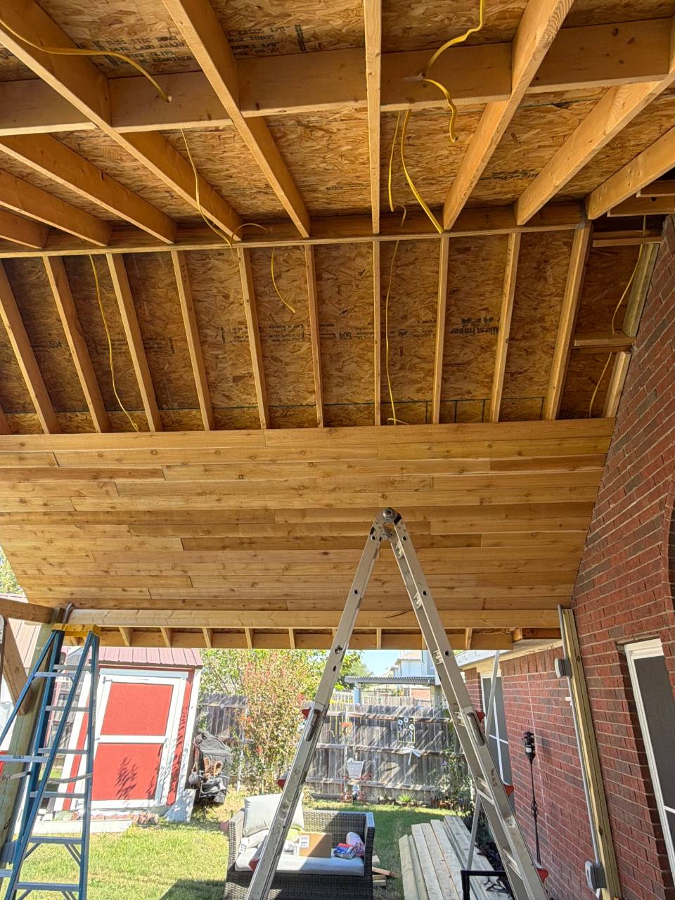 Exposed rafters and timber ceiling during patio roof construction